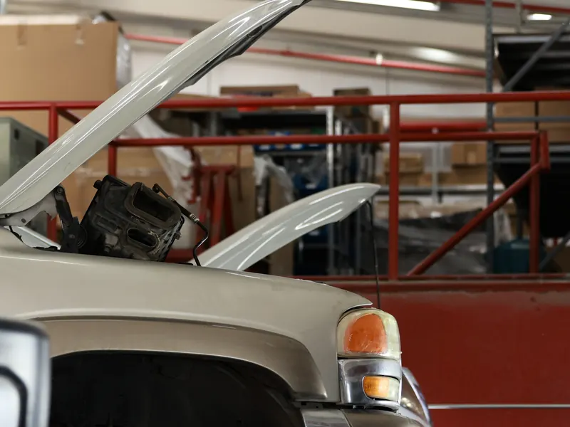 Vehicle with its hood open in the workshop